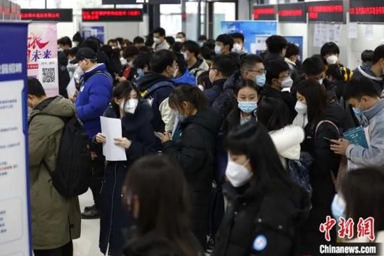 2023年2月8日，北京市教委所属北京高校大学生就业创业指导中心迎来春季首场线下双选会，应聘者排队等候向用人单位提交个人简历。富田 摄